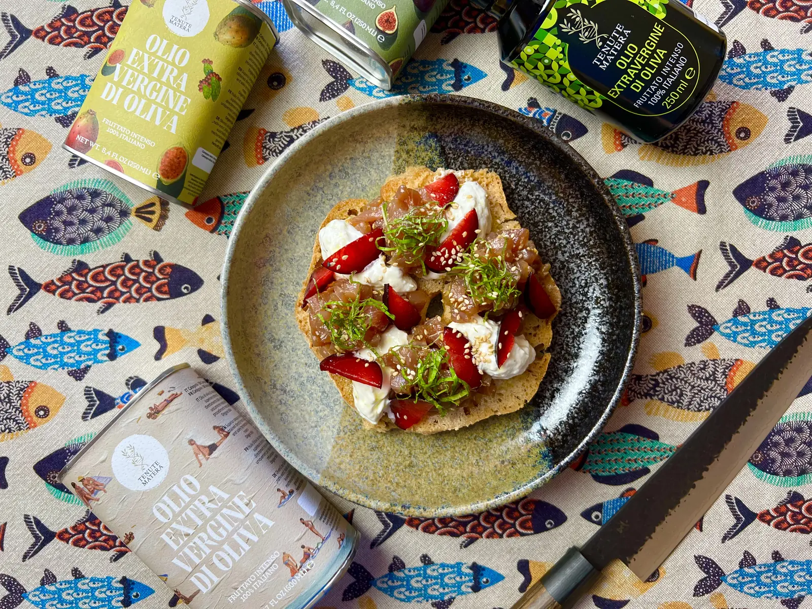 Frisella al brodo dashi con tonno marinato alla giapponese, stracciatella e susine servita su piatto in ceramica